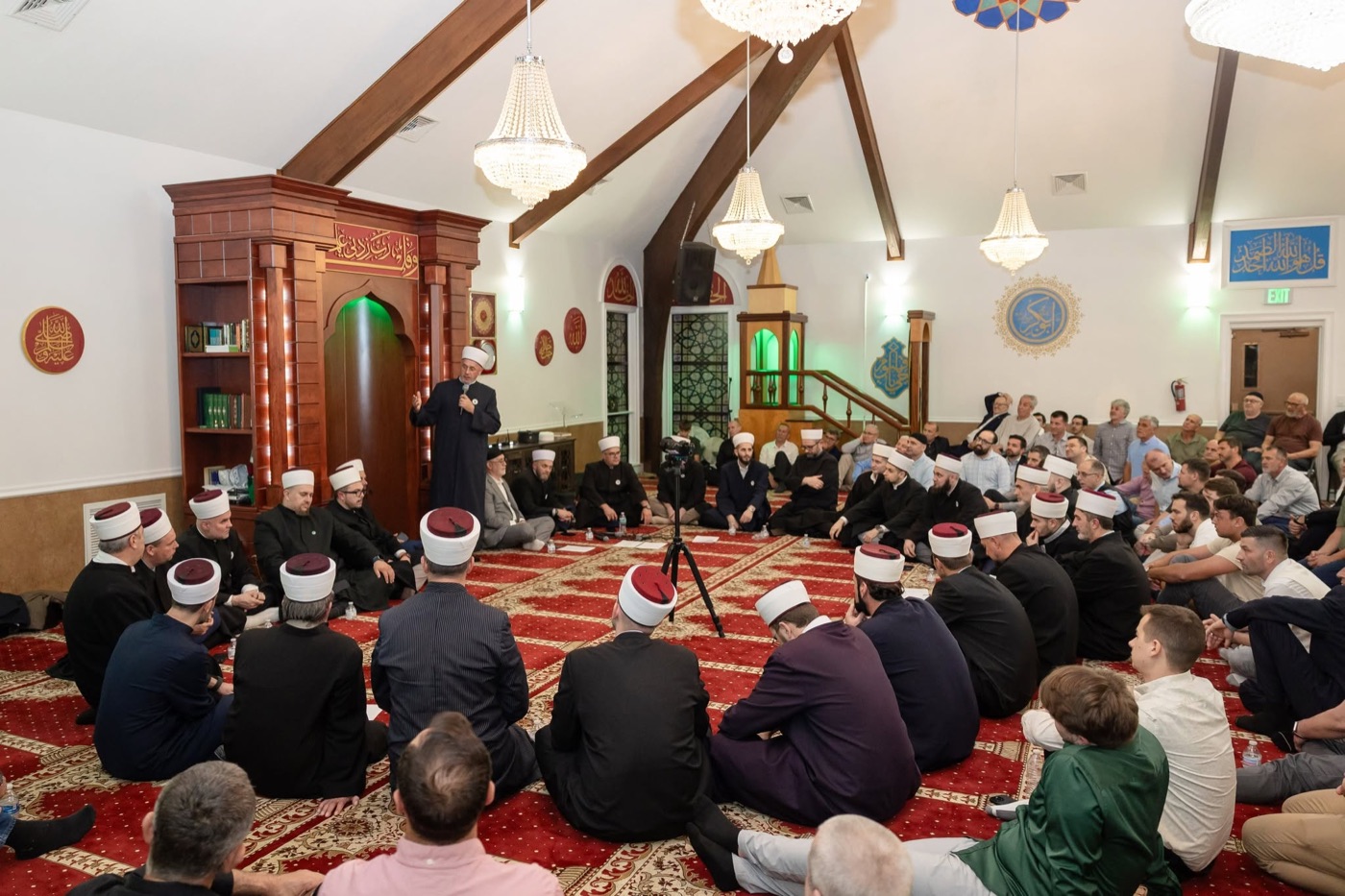 Imams and guests seated on the carpet of the prayer hall during the festive mevlud